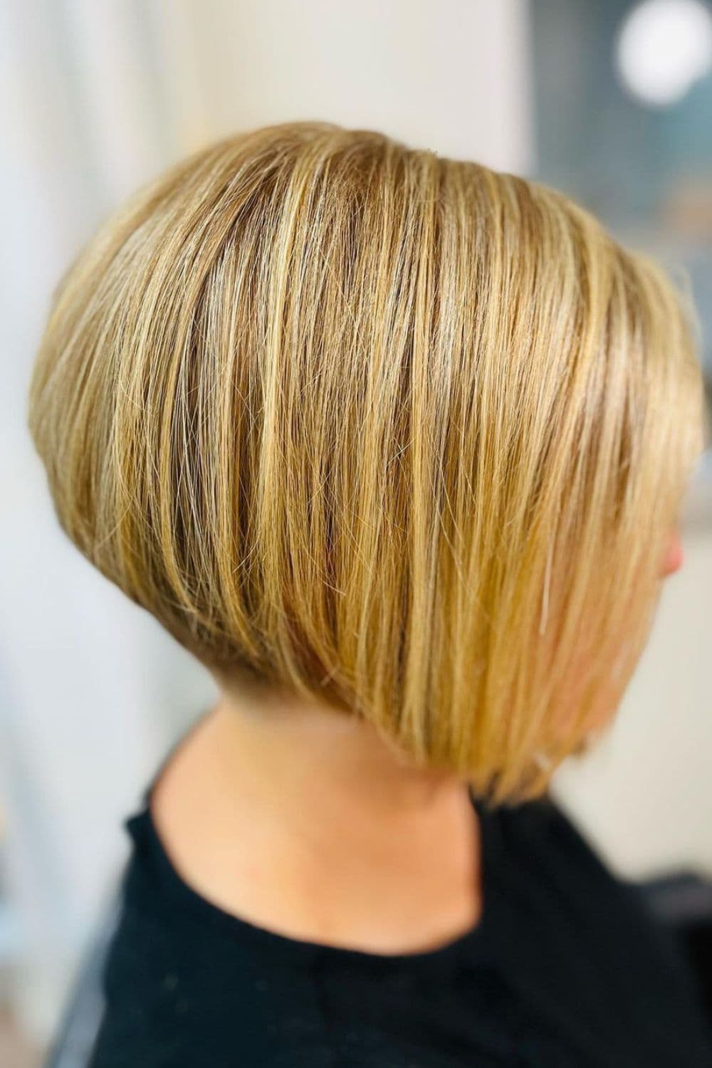 A woman with a blonde, asymmetrical bob cut.