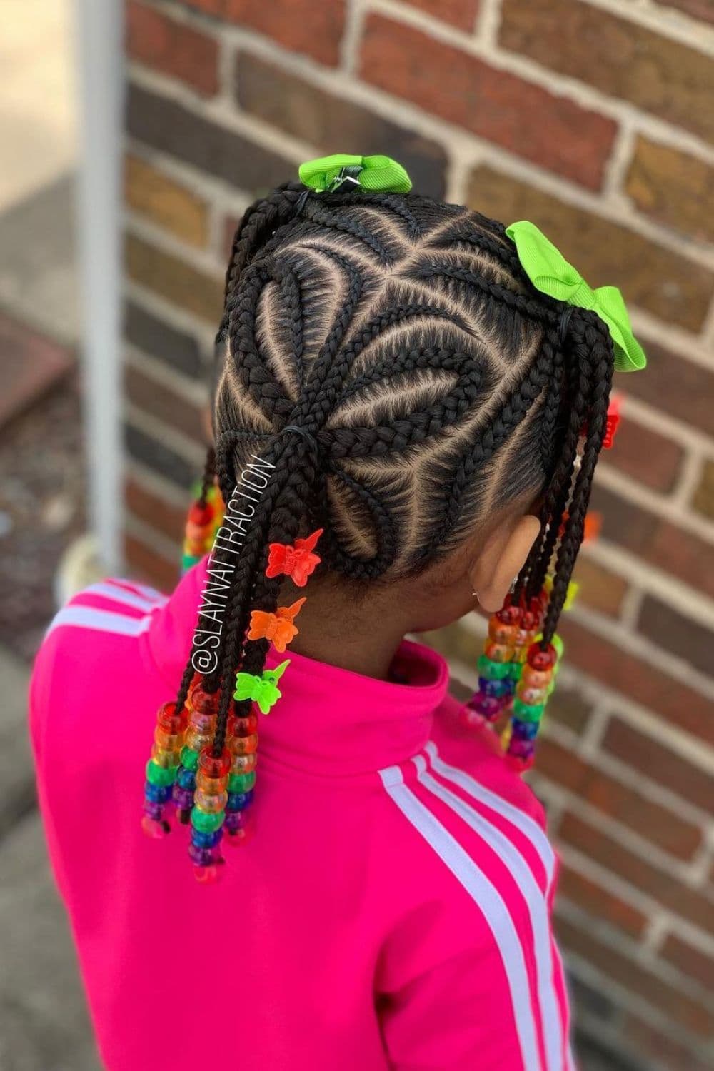 Back view of a child wearing pink long sleeves with beaded butterfly braids hairstyle.