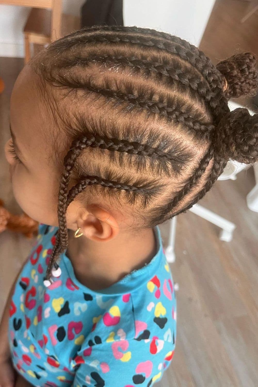 Side view of a little girl with a forward-braided cornrows with beads.