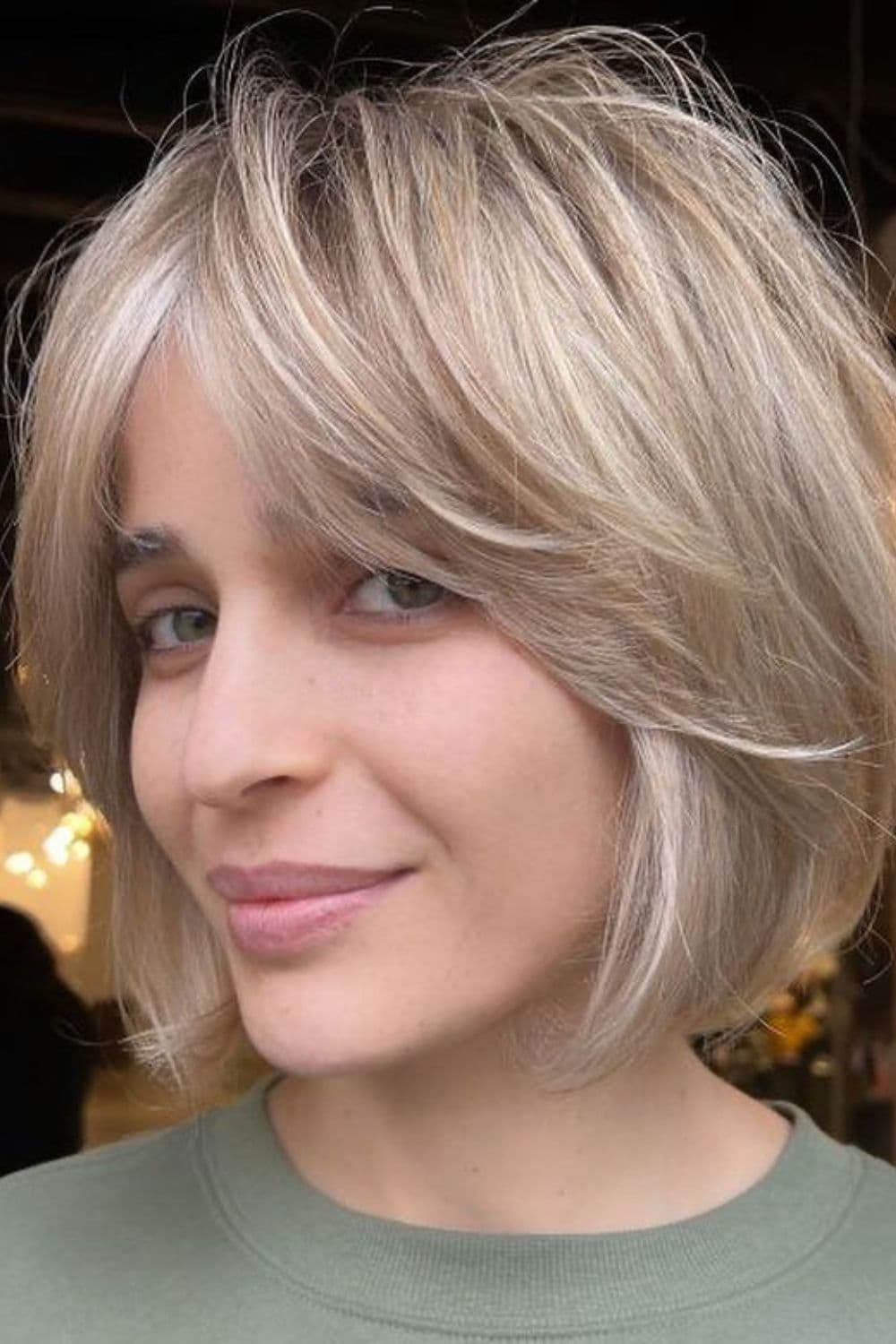 A woman with blonde, short feathered hairstyle.