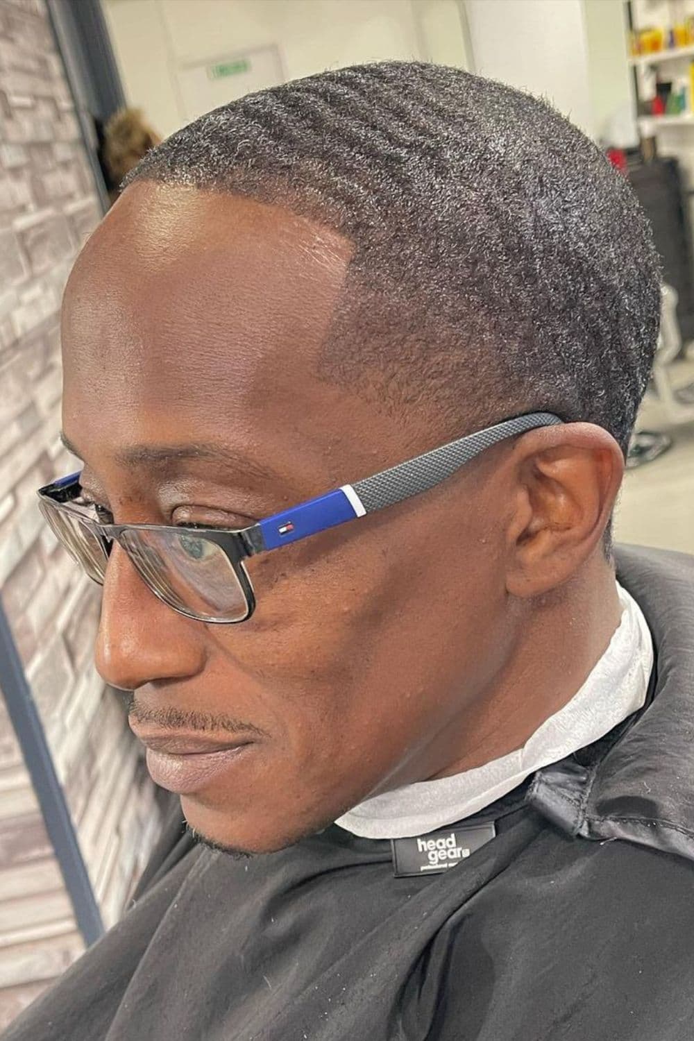 A man with 360 waves with low taper fade and wearing eyeglasses.