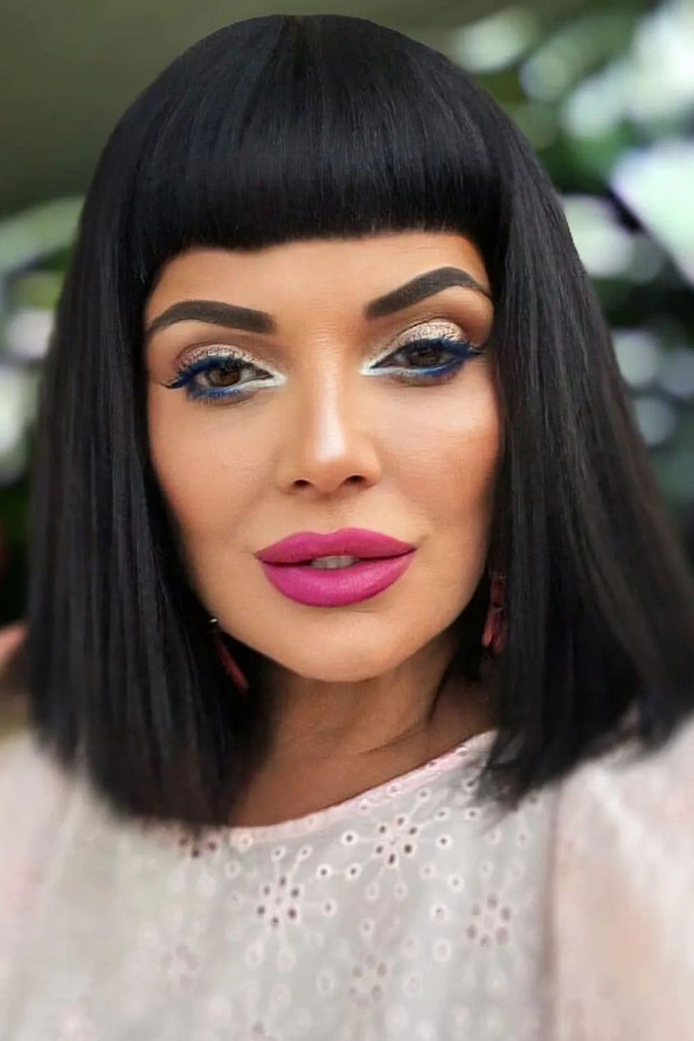 A woman with a black, bang bob with blunt bangs.