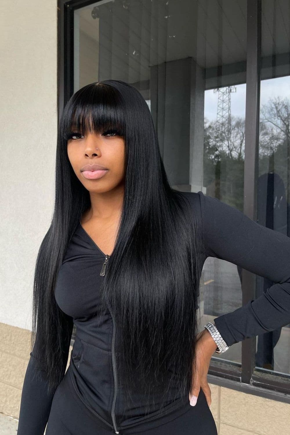 A woman with a black Barbie weave with bangs.