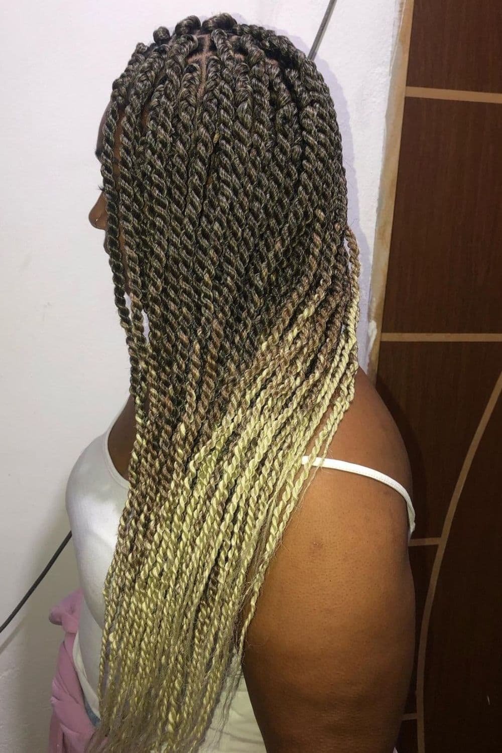 Side view of a woman with big to skinny twists and blonde ends.