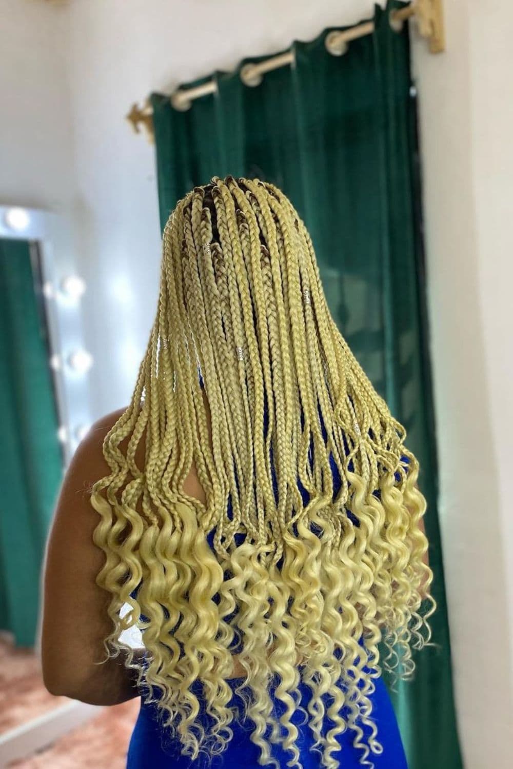 Woman with blonde box braids with big curly ends.