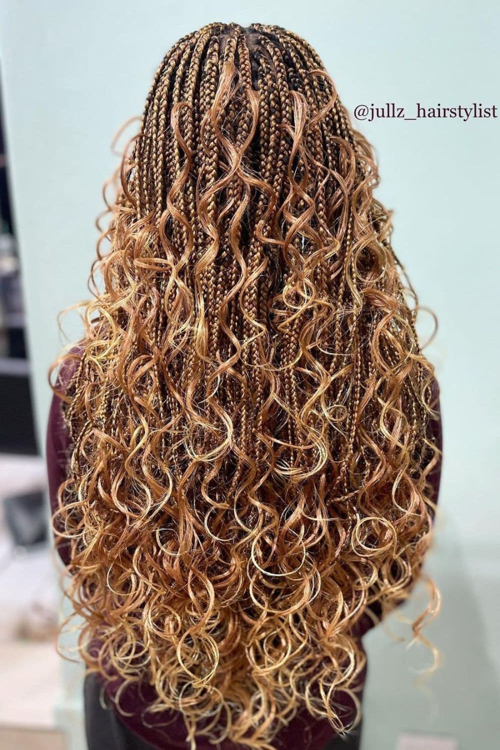 A woman with brown and blonde goddess braids with big curls.