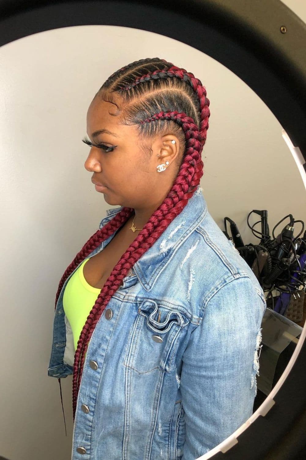 Side view of a woman with burgundy stitch cornrows.