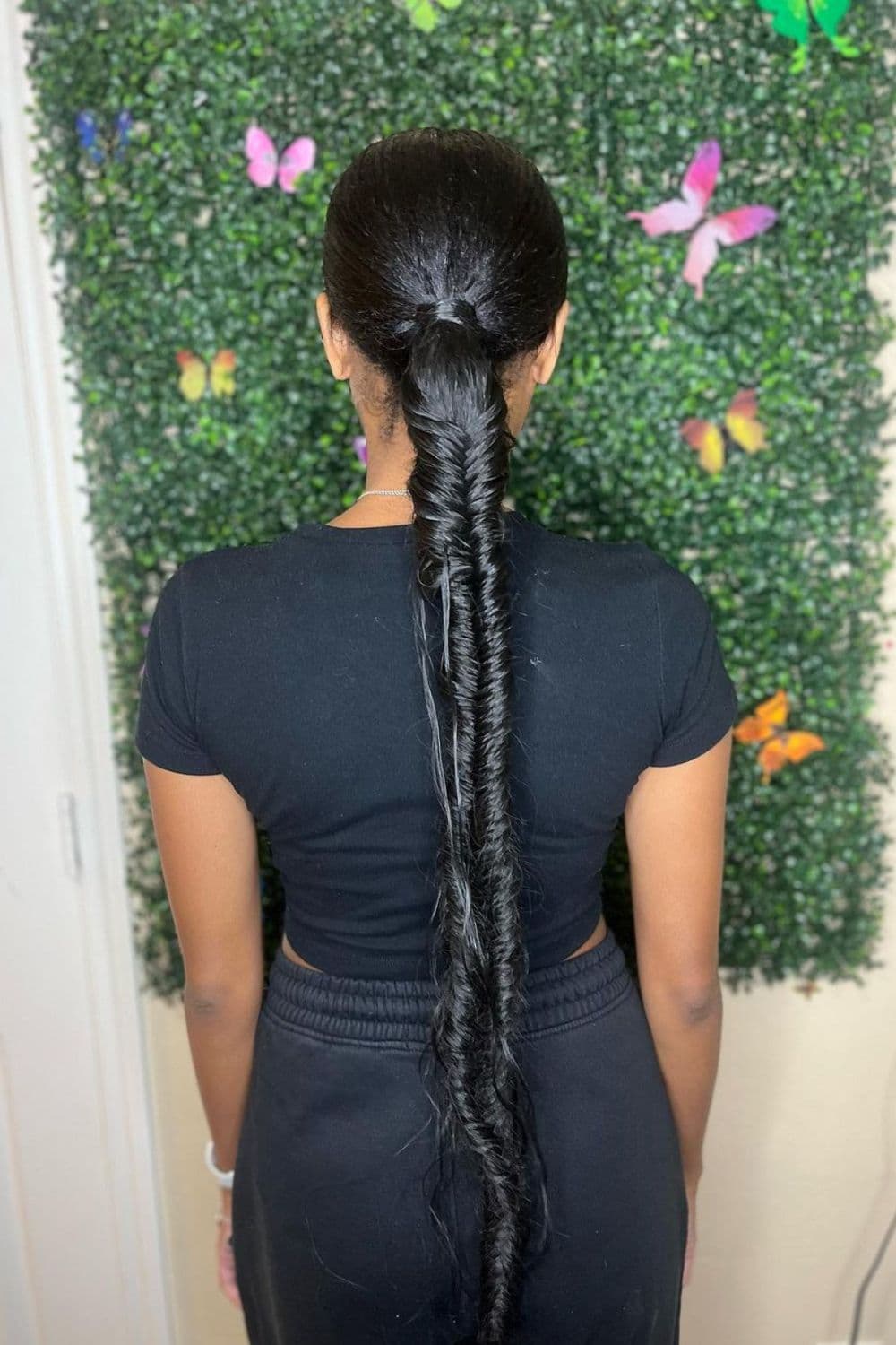 A woman with a black butt-length fishtail braid.