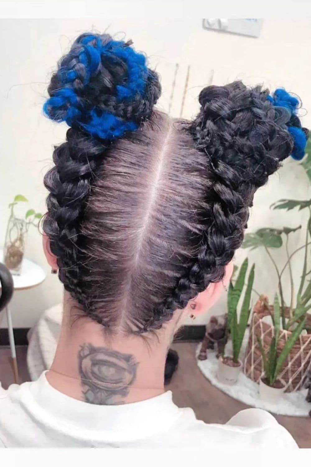 A woman with a black and blue butterfly braid updo.