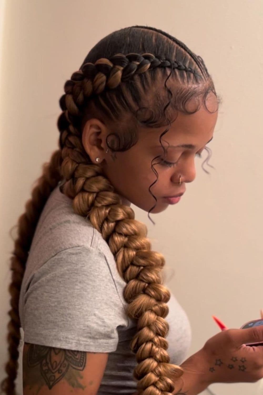 Side view of a woman with butterfly braid with cornrow part.