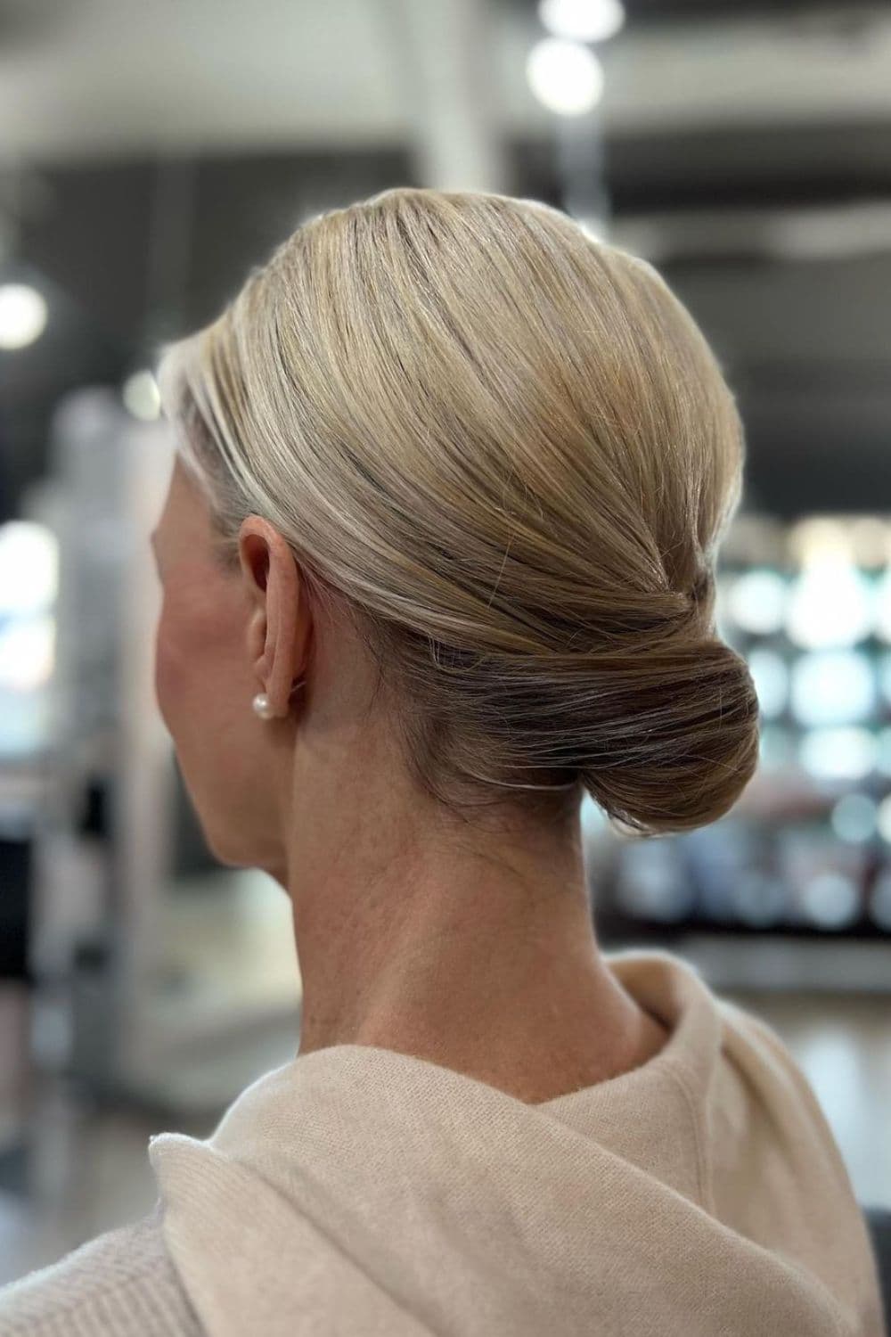 Side view of a woman with a blonde classic chignon.