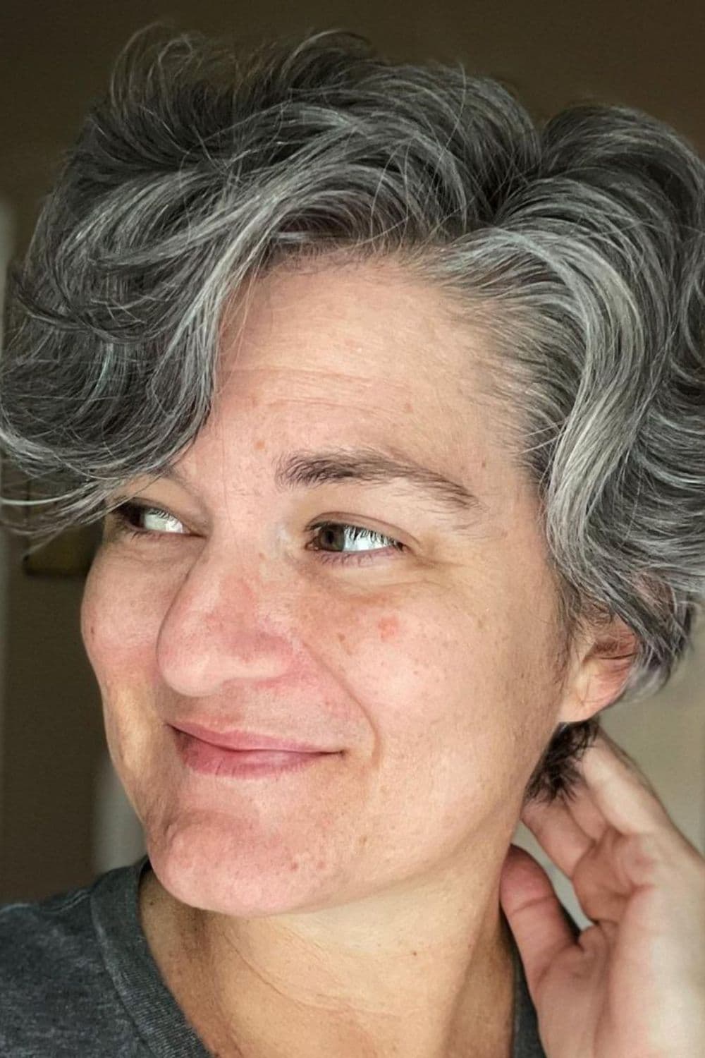 A woman with wavy gray classic pixie cut.