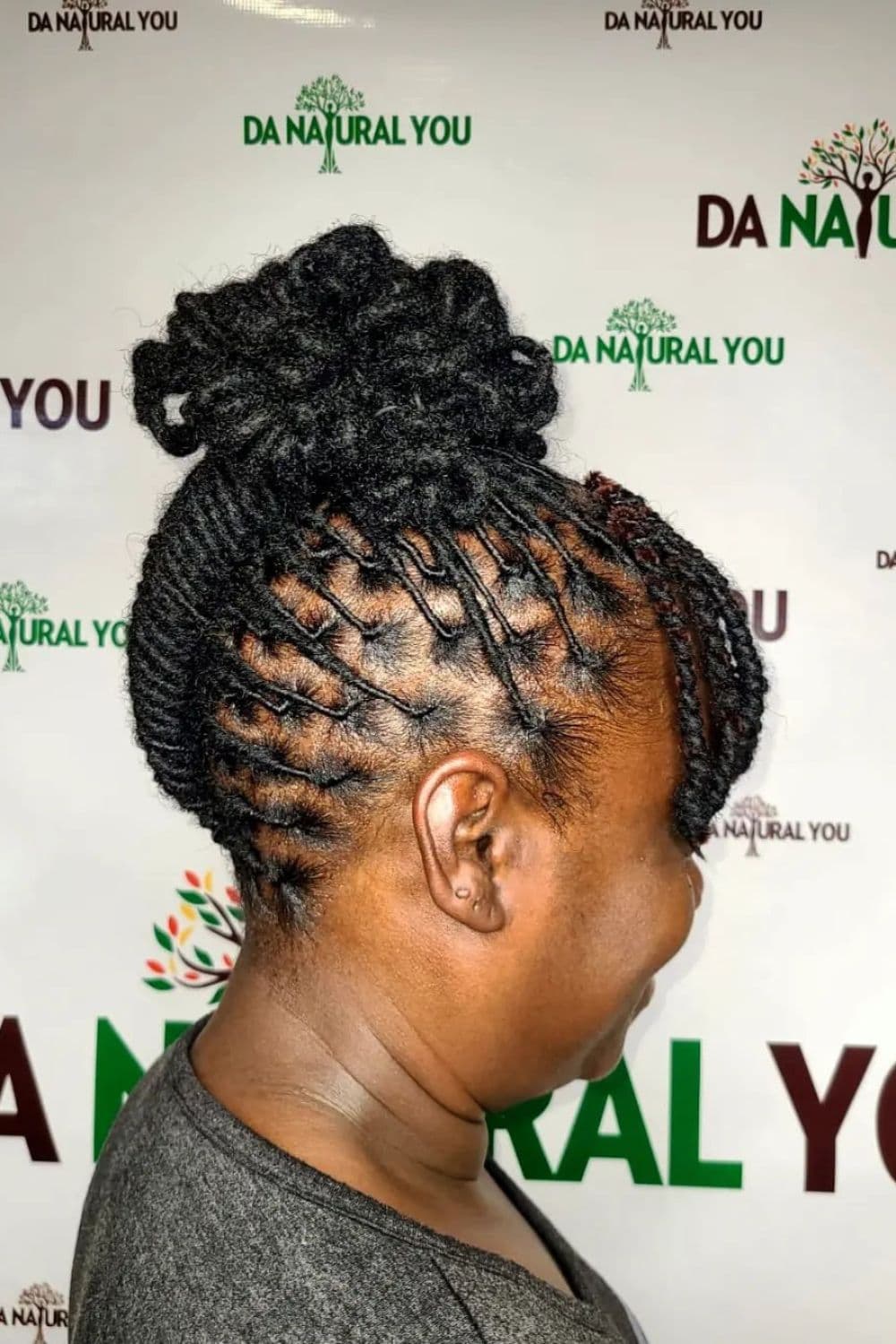 Side view of a woman with a black comb twist updo.