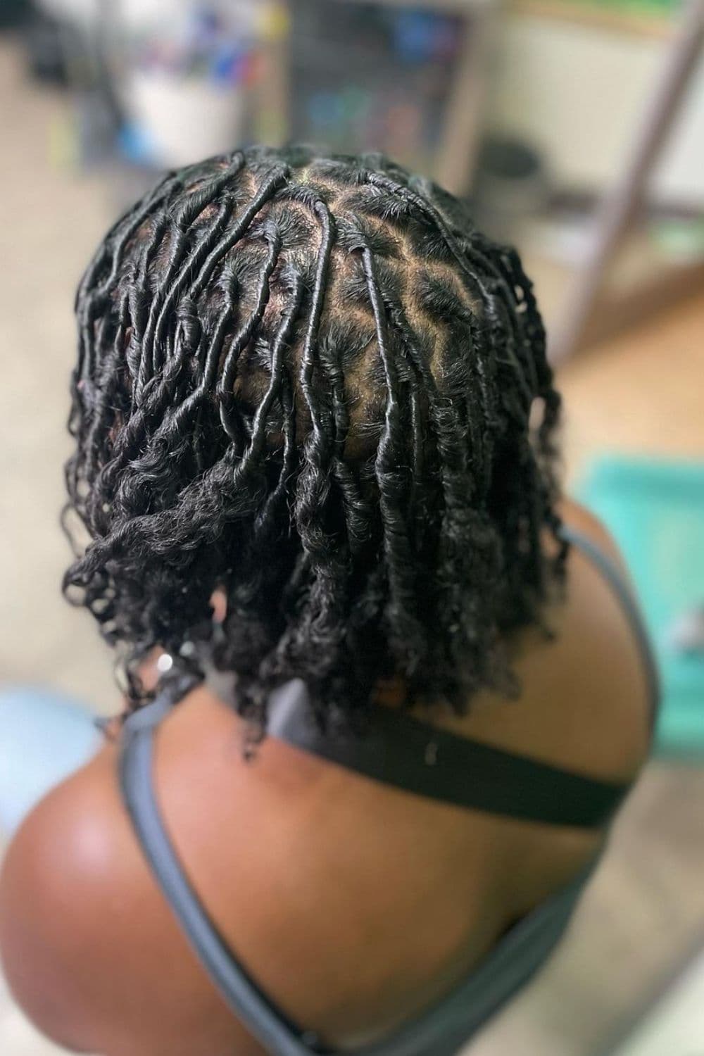 A woman with a black comb twist with curly ends.