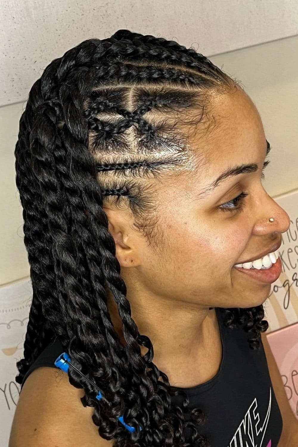 Side view of a woman with black cornrows with a two-strand twists hairstyle.