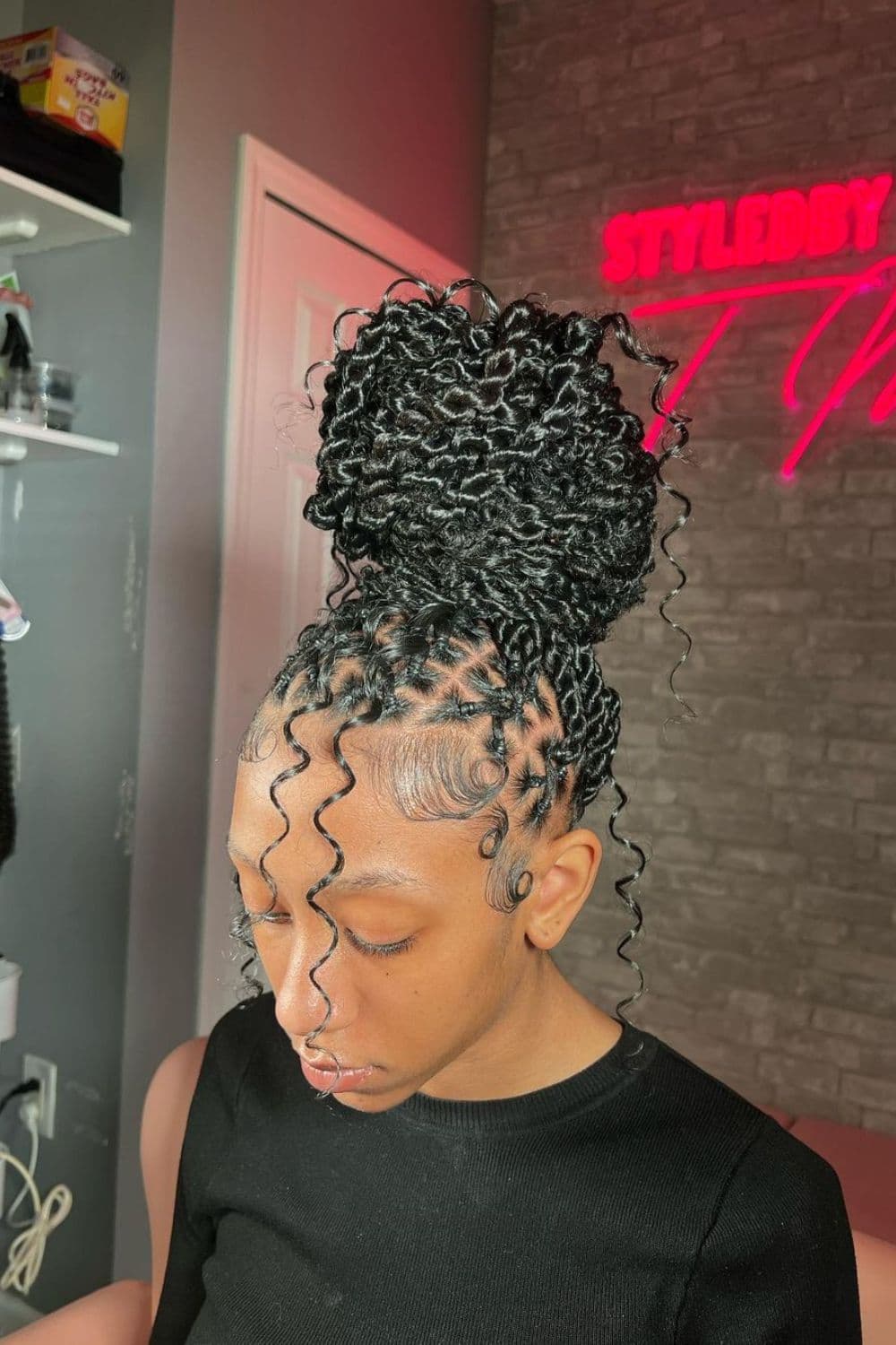 A woman with a black crisscross passion twists high bun.