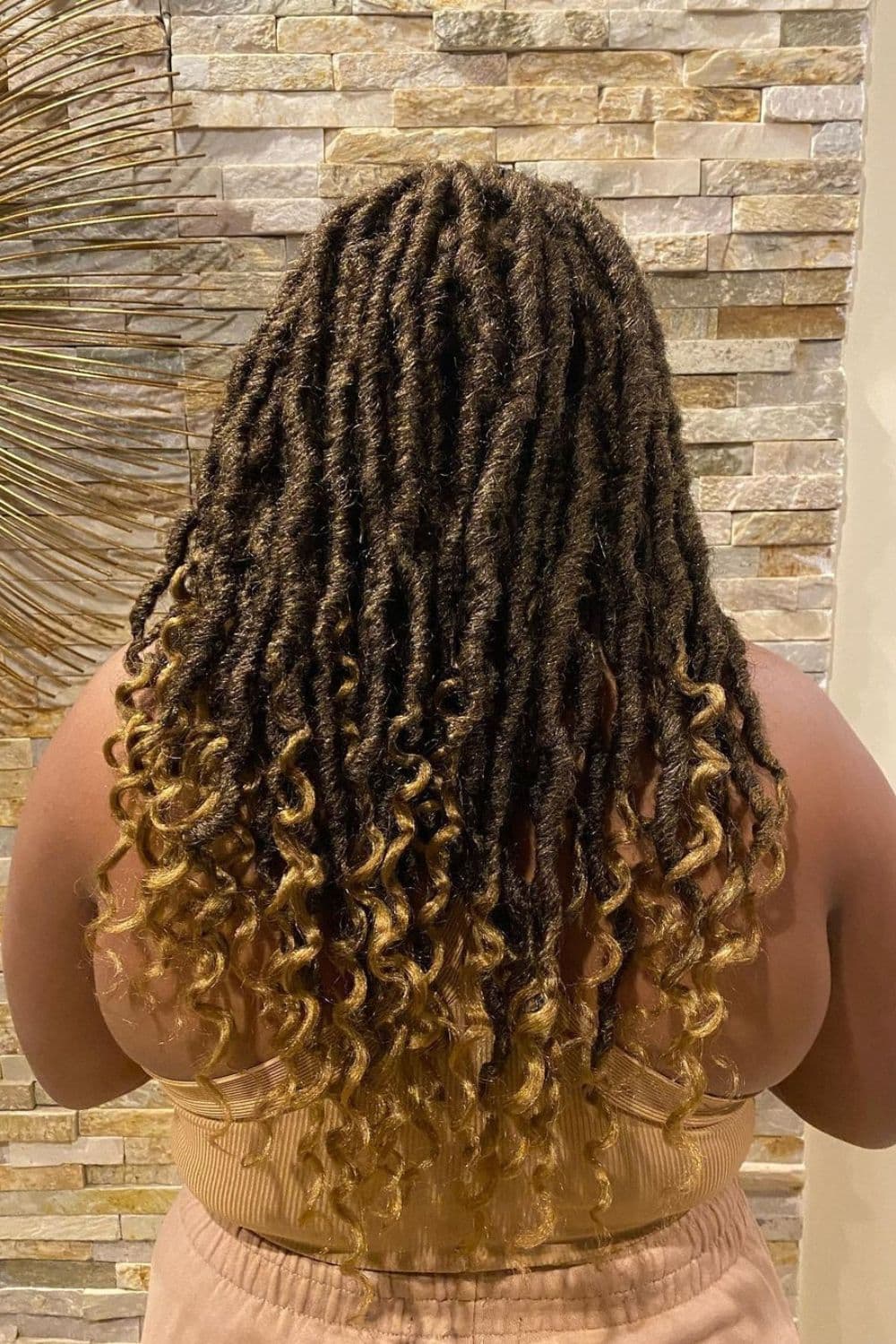 Back of a woman with ombre blonde crochet goddess locs.