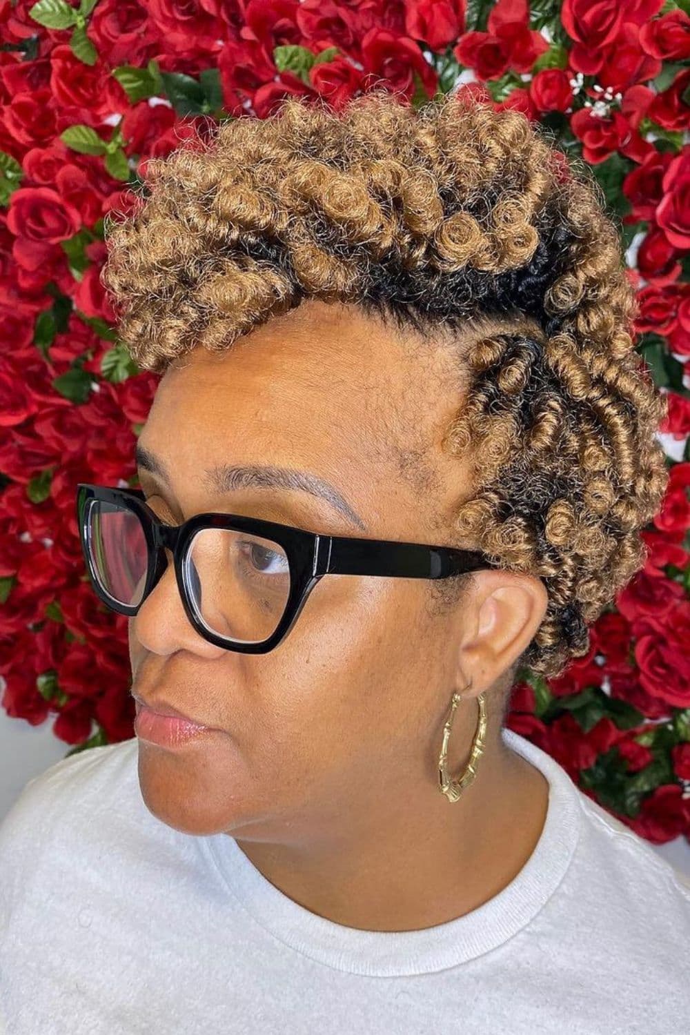 Side view of a woman wearing eyeglasses and a blonde curly crochet pixie.