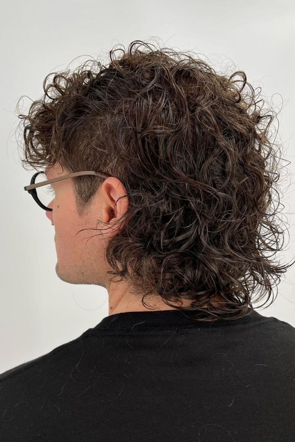 A man with curly undercut mullet.