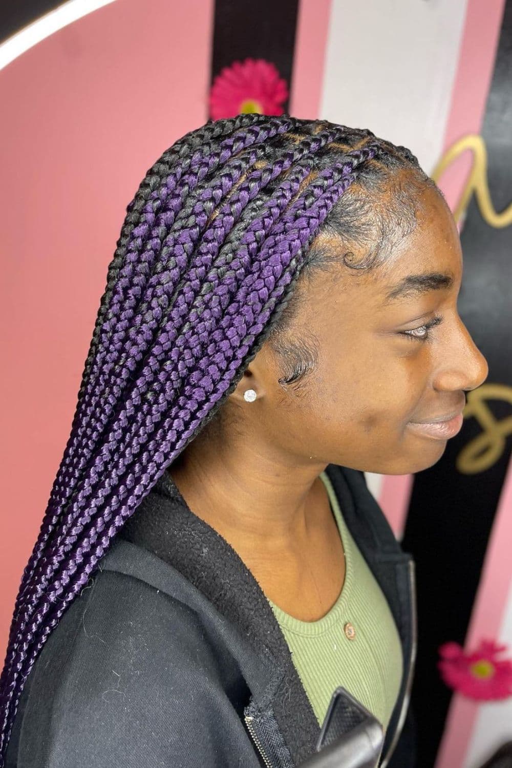 Side view of a girl with dark purple knotless braids.