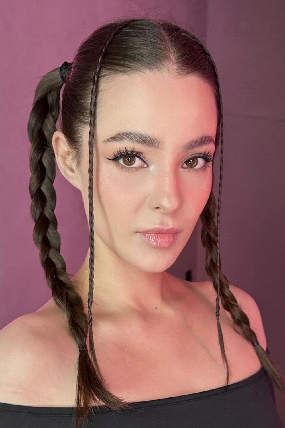A woman with high pigtails and face-framing plaits.