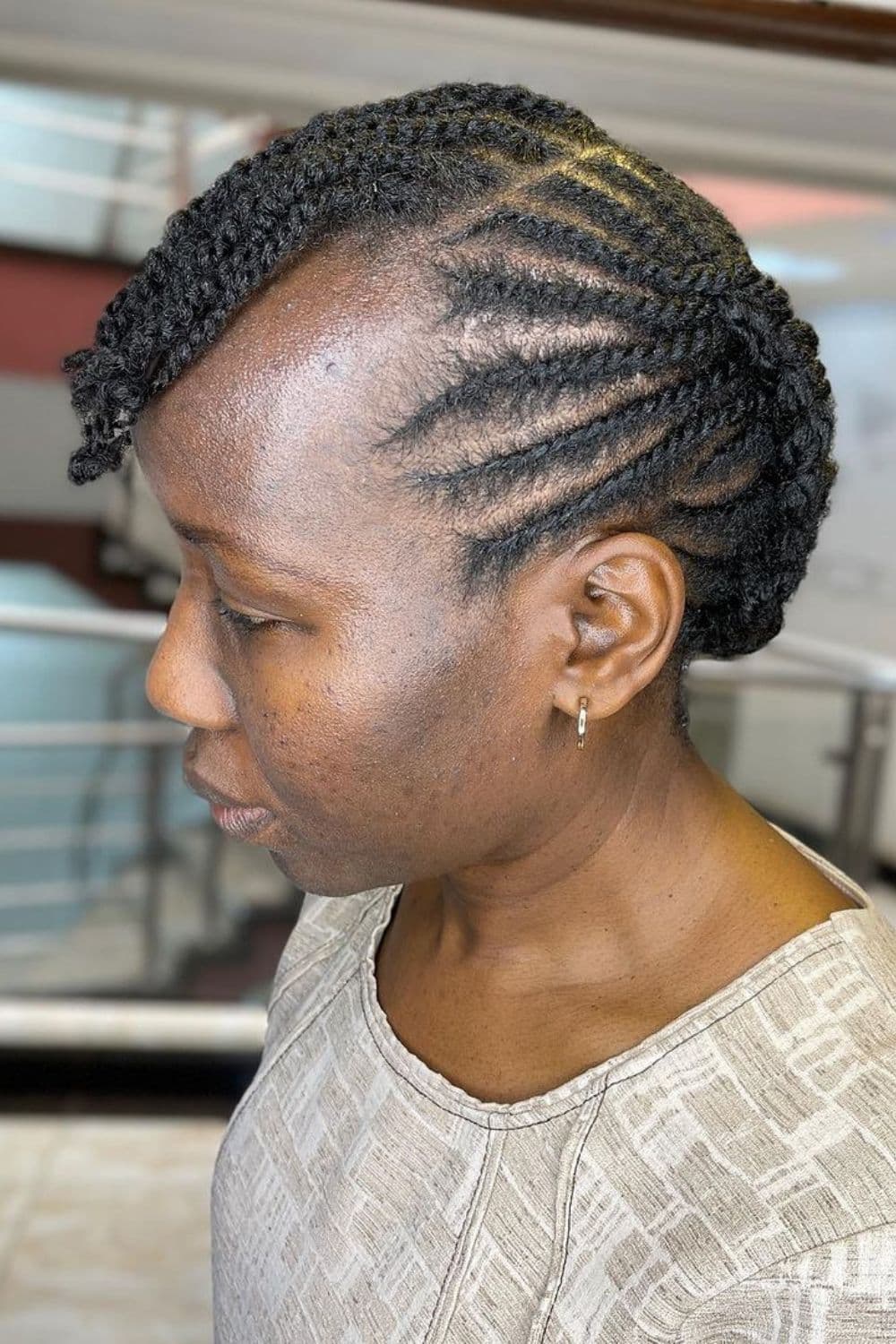 Side view of a woman with black flat twists updo.