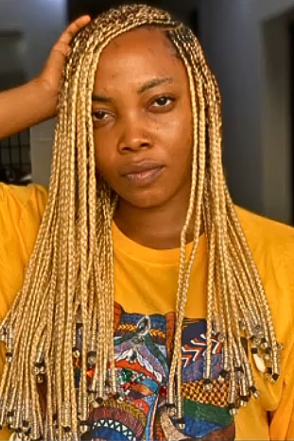 A woman with blonde Ghana braids with beads.