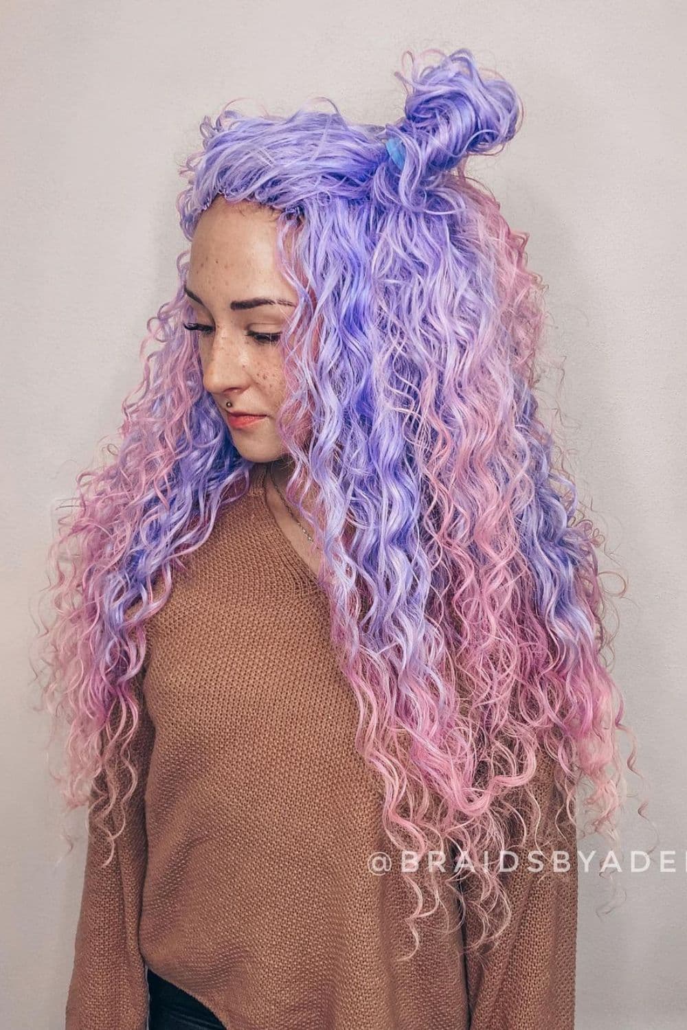 A woman with pastel pink and pastel purple half-up half-down crochet curls.