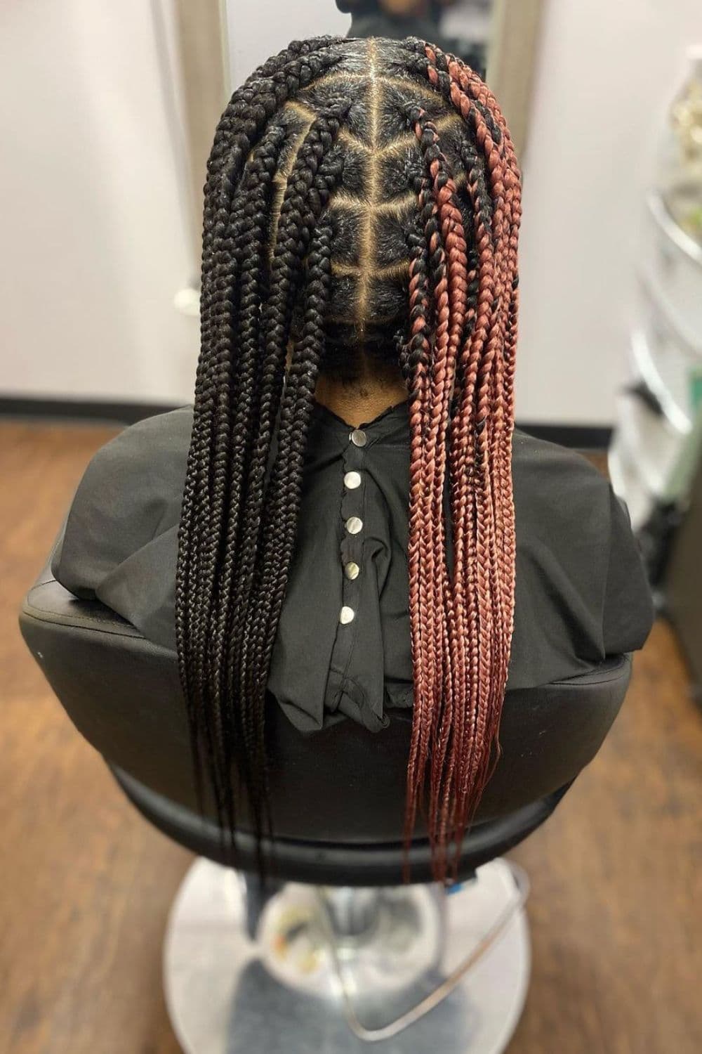 Back of a woman with black and brown half and half knotless braids.