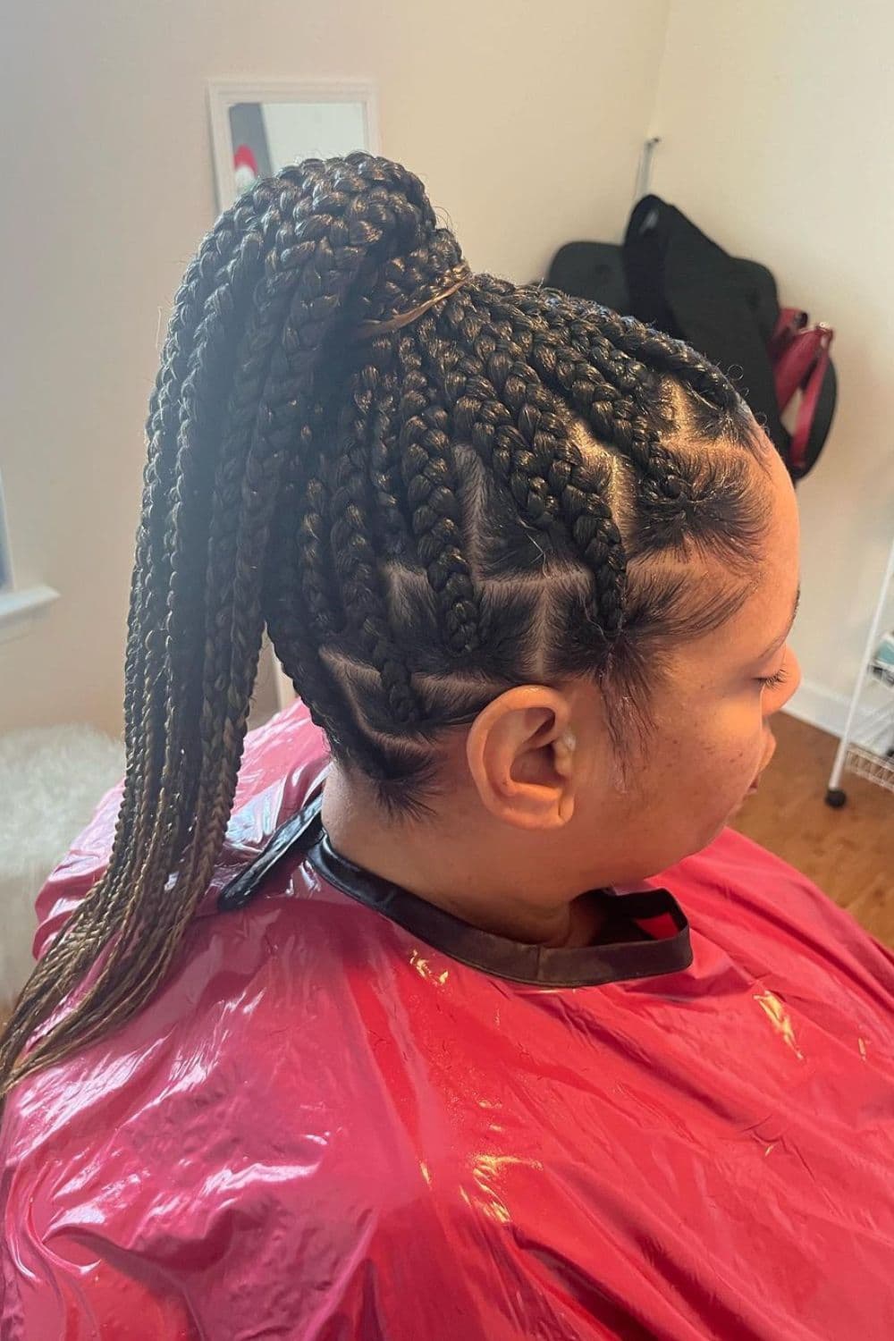 Side view of a woman in high ponytail knotless braids.