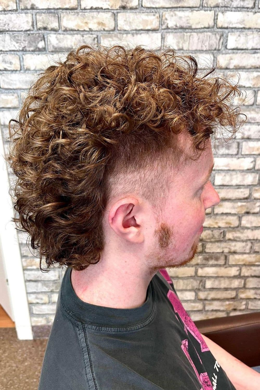 Side view of a man with high volume curly mullet.