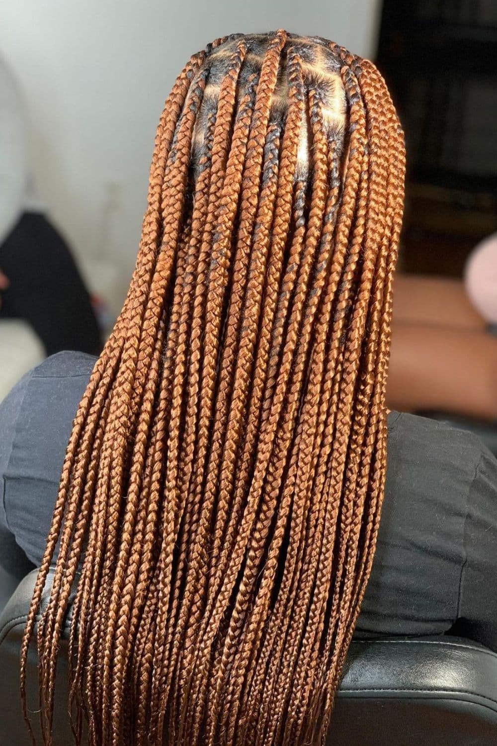 A woman with honey blonde knotless braids.