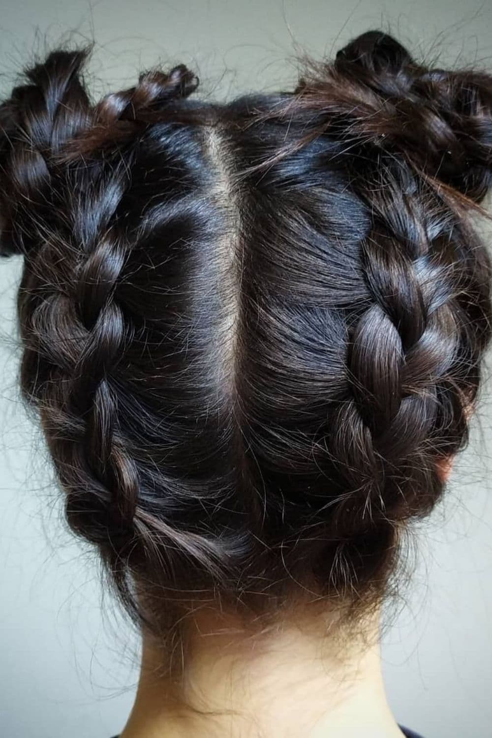 Close-up shot of a woman's hair with inverse Dutch braids with buns.
