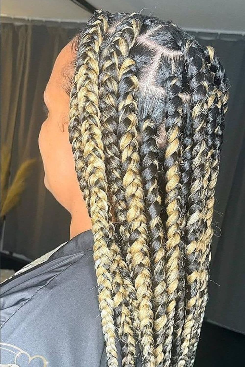 Side view of a woman with jumbo mixed blonde knotless braids.