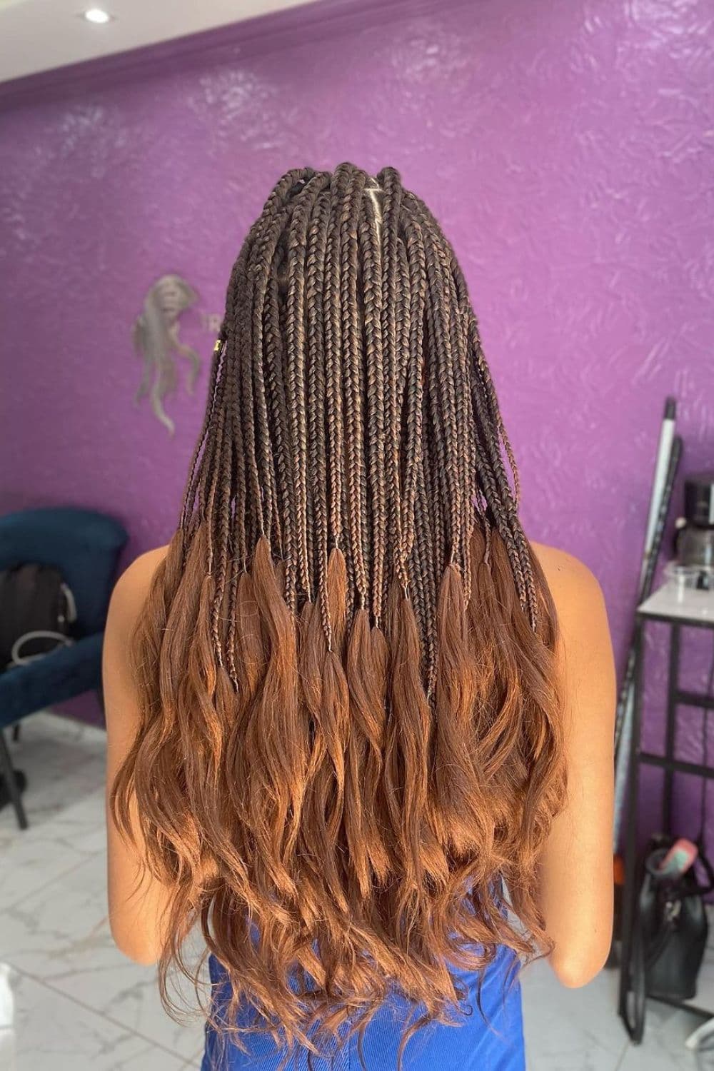 A woman with brown knotless braids with loose ends.
