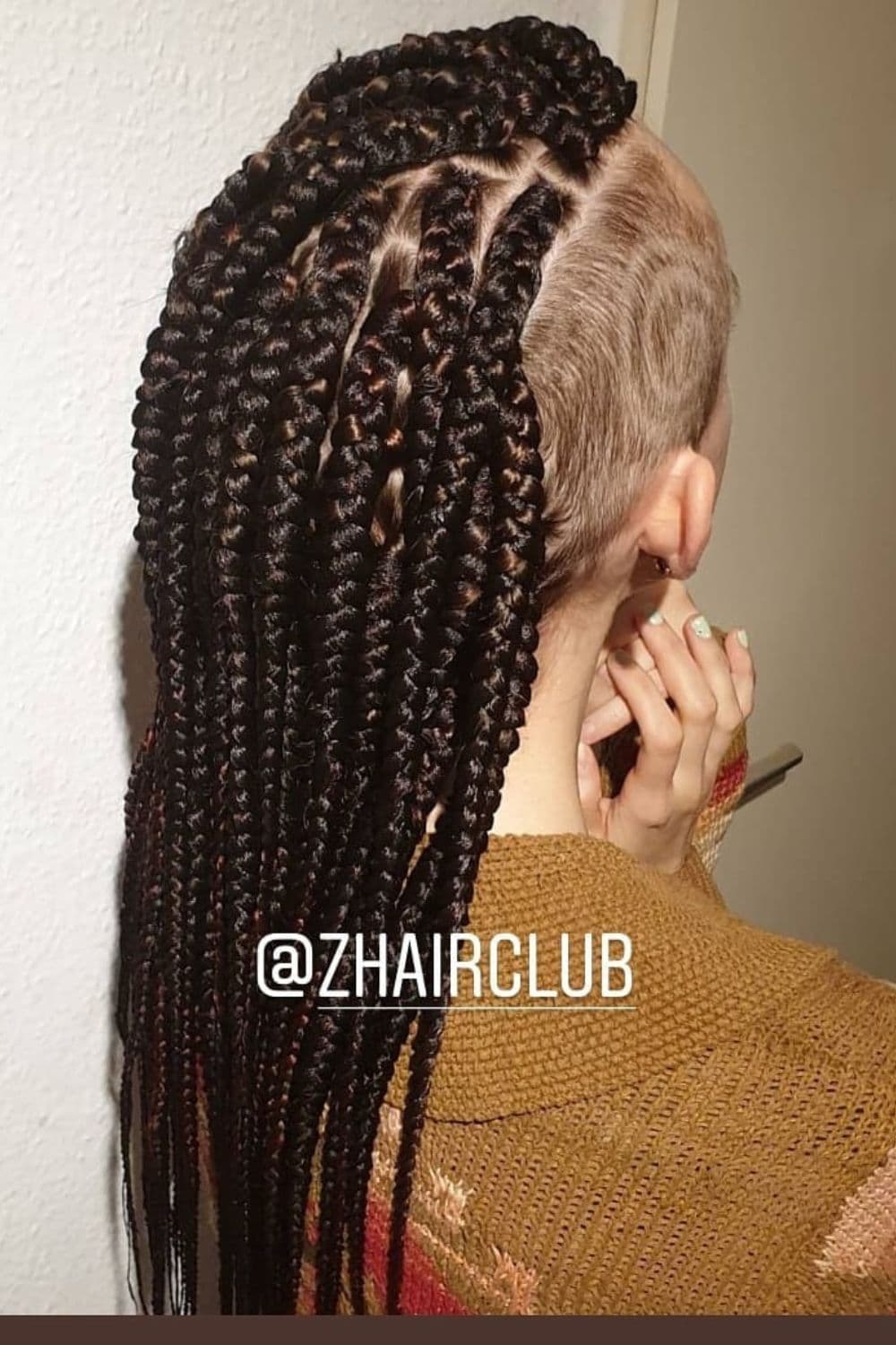 A woman with black knotless braids with a shaved side.