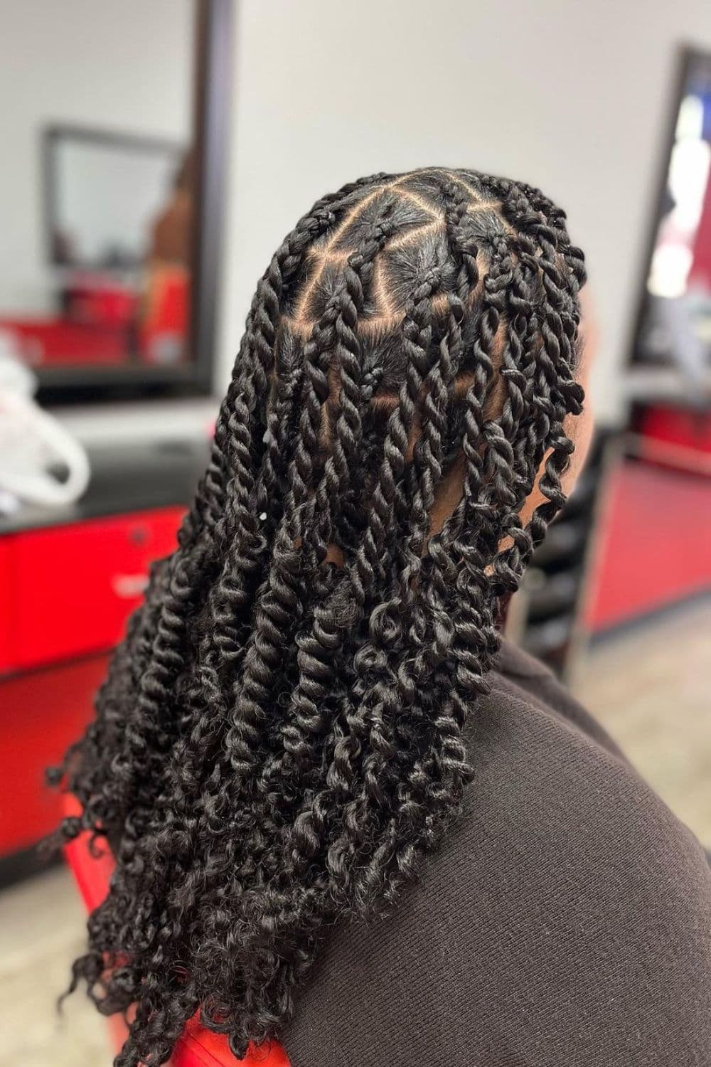 Side view of a woman with black knotless passion twists.