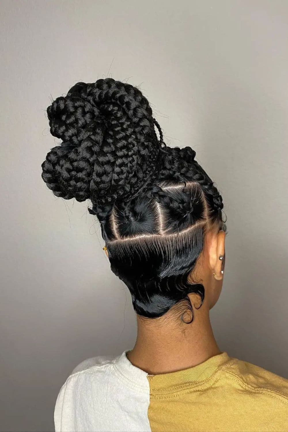 A woman with black large knotless braids into a bun.