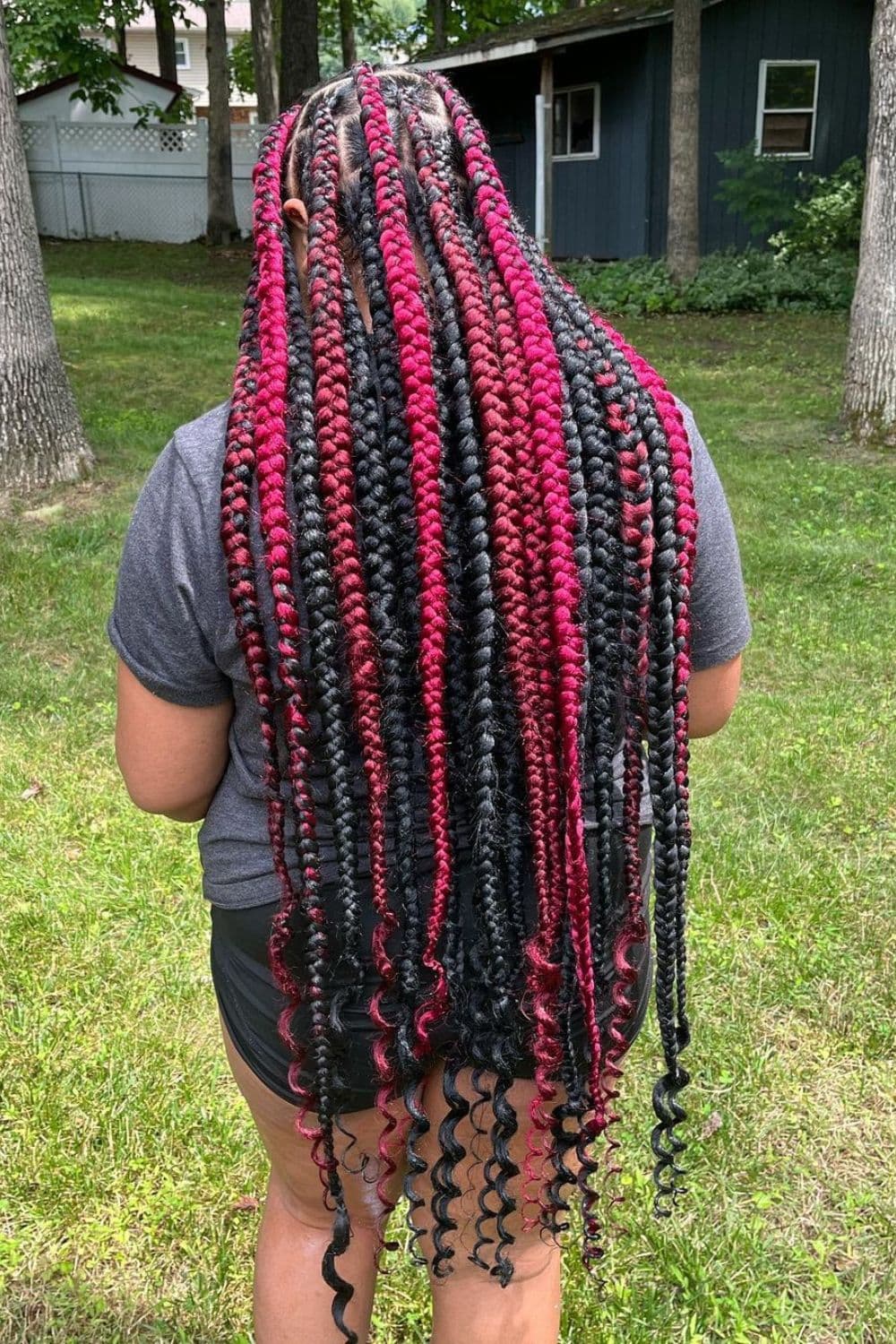 A woman with black and red long box braids with curly ends.