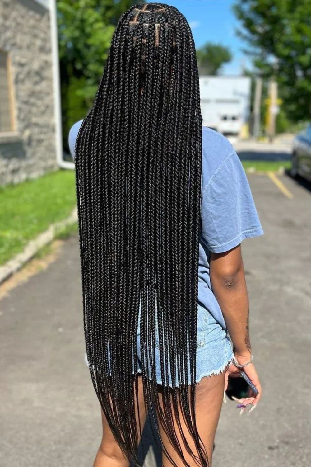 Back of a woman with black long medium knotless braids.