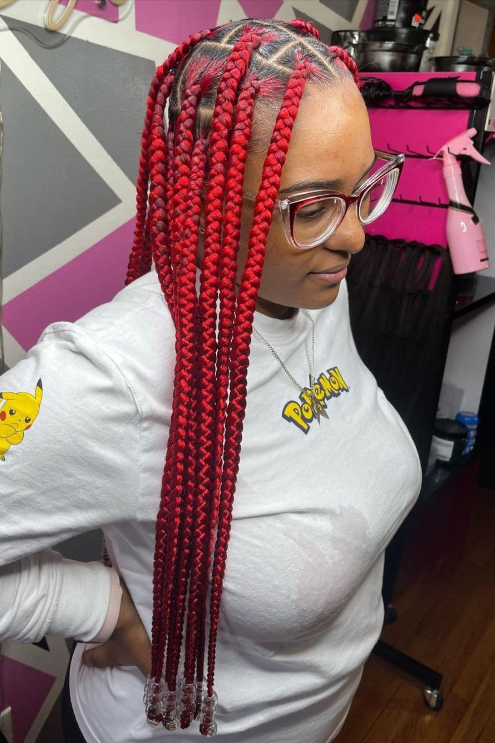 Side view of a woman with long, red jumbo braids.