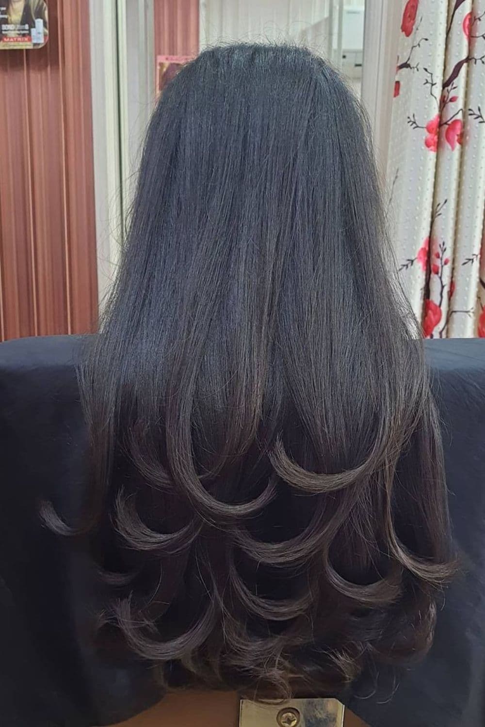 A woman's hair in black, long step layers.