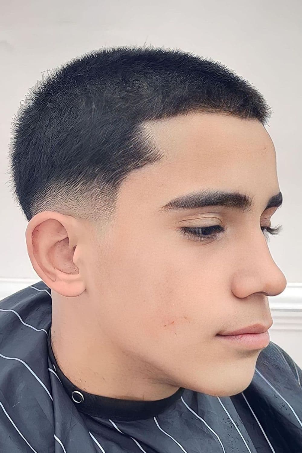 Side view of a man with low taper fade buzz cut.