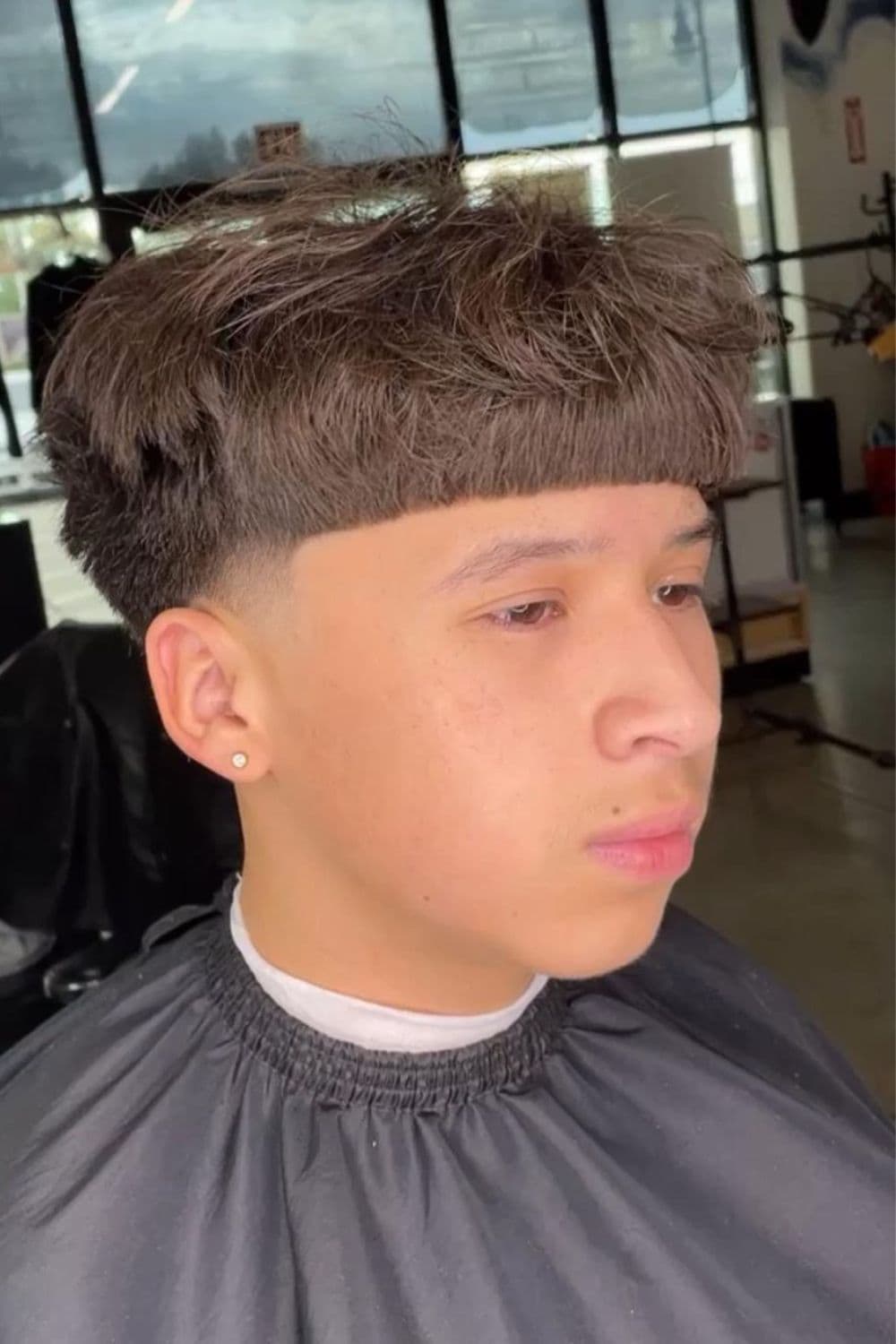 A man with low taper fade with short bangs.