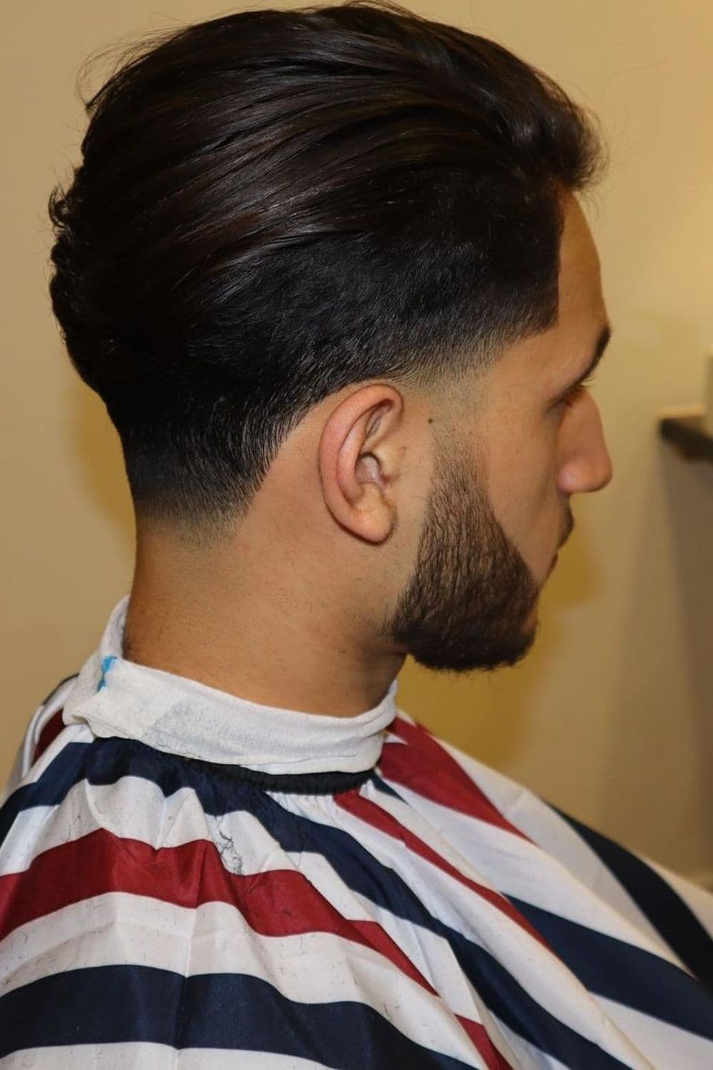 Side view of a man with low taper slick back.