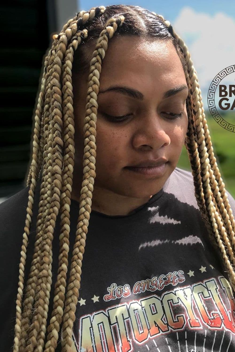 A woman with medium honey blonde box braids.