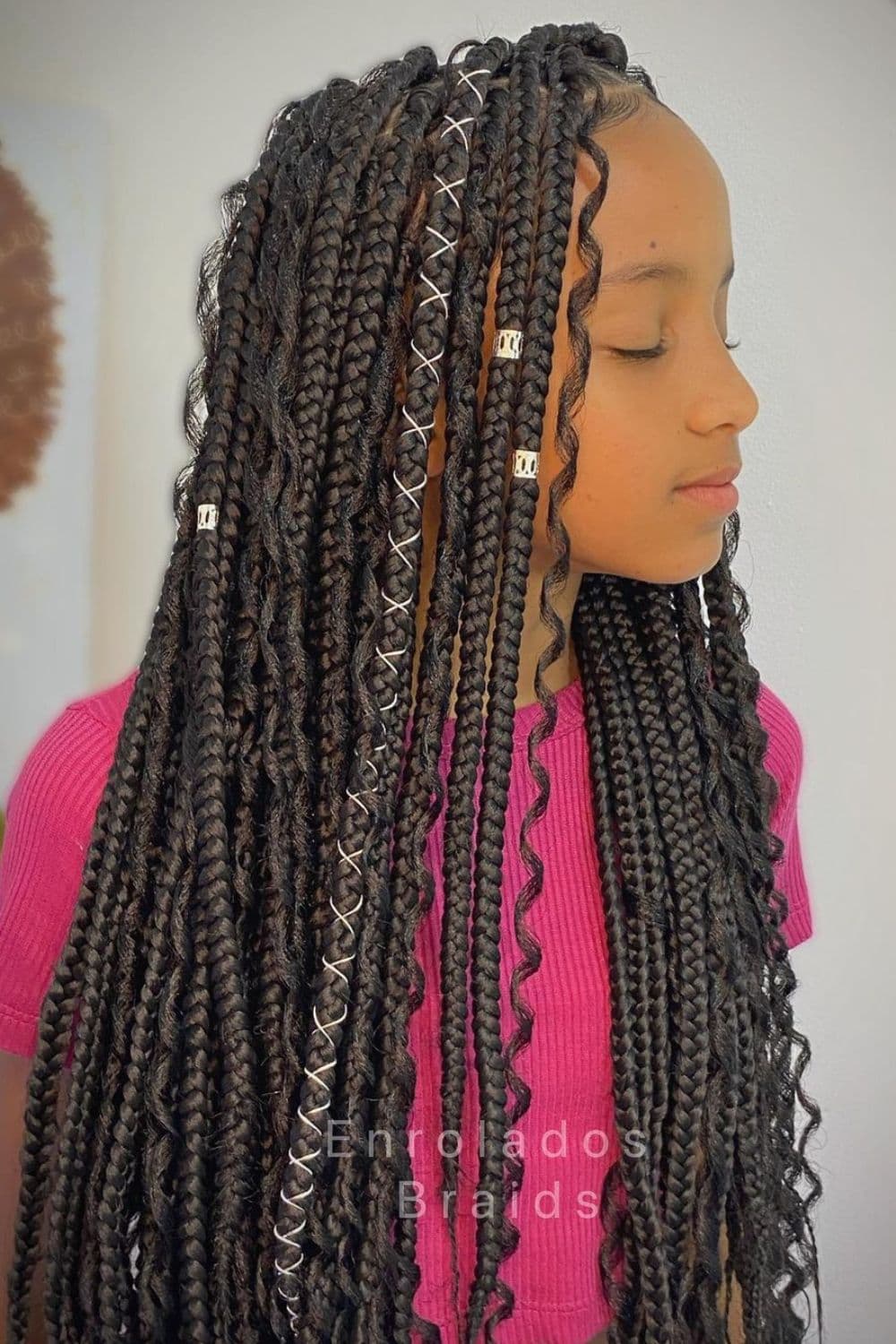 Side view of a girl with black medium knotless braids with threads and cuffs.