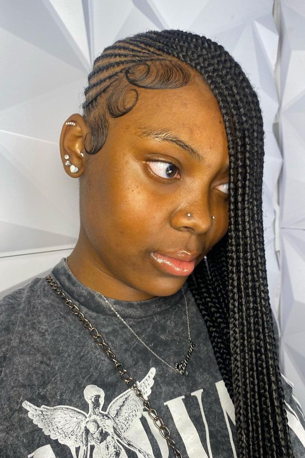 Side view of a woman with black medium knotless lemonade braids.