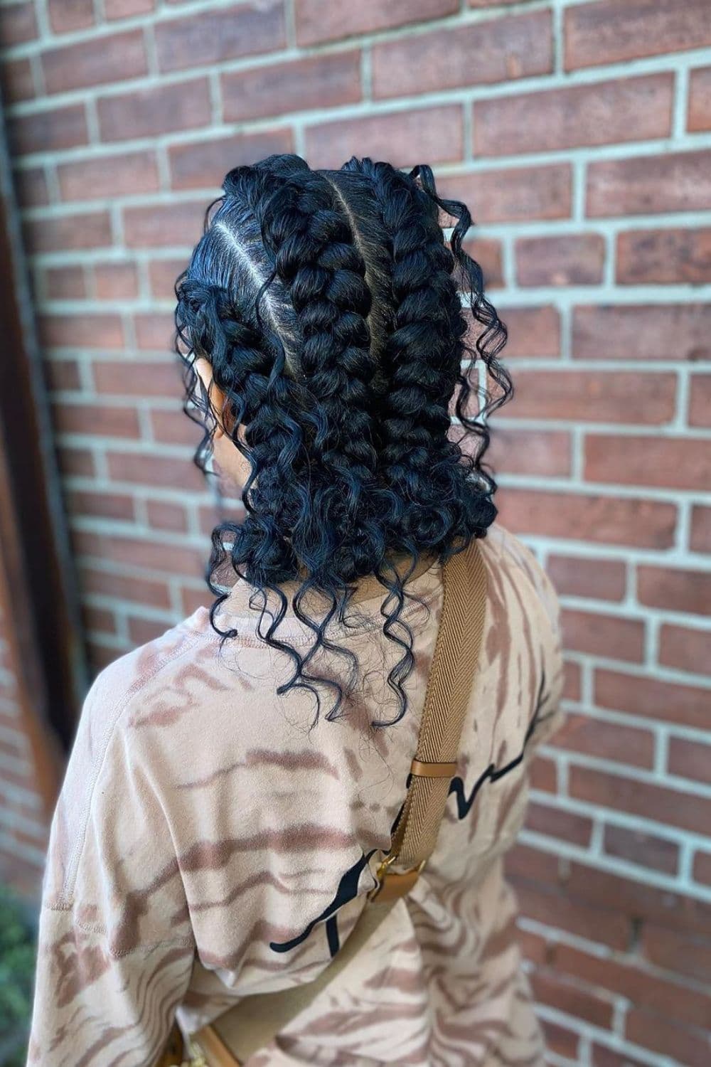A woman with three butterfly braids with loose curls.