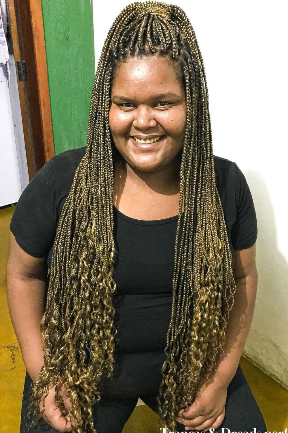 A woman with blonde micro box braids with curly ends.